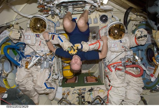 Kotov poses with Orlan-MK Suits in the Pirs DC-1 during Expedition 22