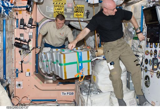 Kelly and Kondratyev moves food stowage containers in the Node 1