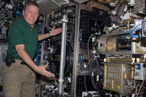 Expedition 28 FE Fossum poses for a photo next to the CIR in US Lab