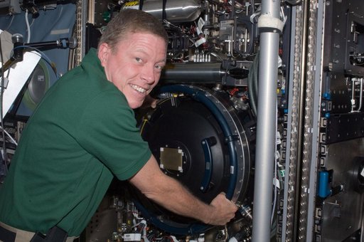 Expedition 28 FE Fossum poses for a photo next to the CIR in US Lab