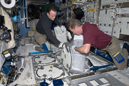 Expedition 28 Crew Members remove samples from the JPM MELFI