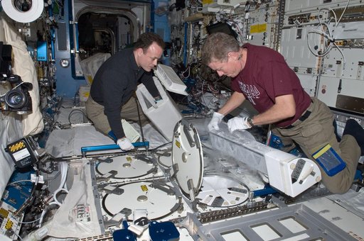 Expedition 28 Crew Members remove samples from the JPM MELFI