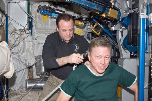 View of Expedition 28 Crew Members giving and receiving a haircut in the Node 3