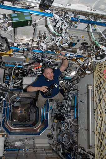 Ivanishin holds a still camera while floating through the U.S. Laboratory