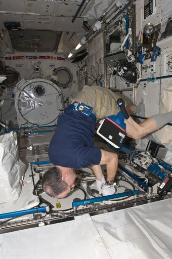 Pettit prepares to insert biological samples in the MELFI-1 in the JPM
