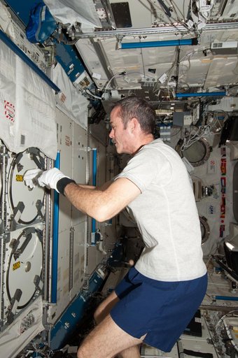Hadfield prepares to insert biological samples in the MELFI-1
