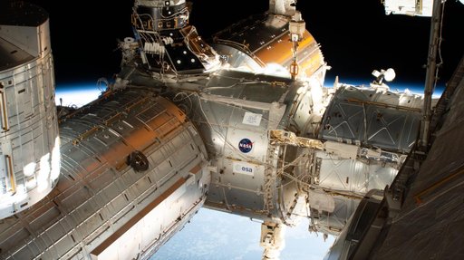 The forward end of the International Space Station is pictured showing portions of five modules.