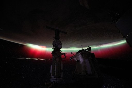 A vibrant green and red aurora shimmers above New Zealand