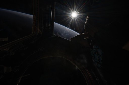 The setting sun highlights Earth's horizon