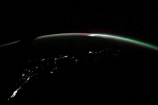 The aurora australis blends with Earth's atmospheric glow