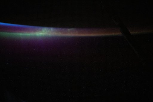 The aurora australis blends into Earth's atmospheric glow