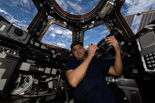 Astronaut Matthew Dominick poses for a portrait in the cupola with his camera