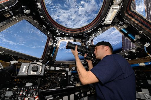 Astronaut Matthew Dominick points his camera out a window on the cupola
