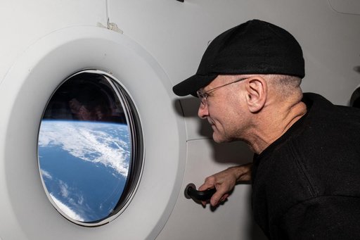 Astronaut Don Pettit looks out a window on the SpaceX Dragon Endeavour spacecraft