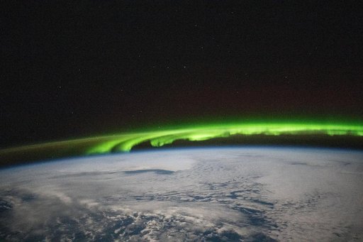 A bright green aurora borealis streams above Earth's surface