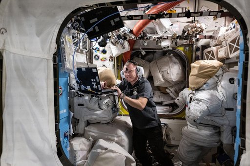 Cosmonaut Aleksandr Gorbunov wears headphones and conducts a hearing test