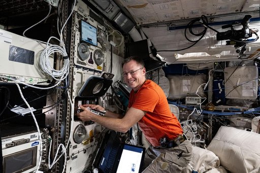 Astronaut Nick Hague processes radiation-resistant samples of micro-algae