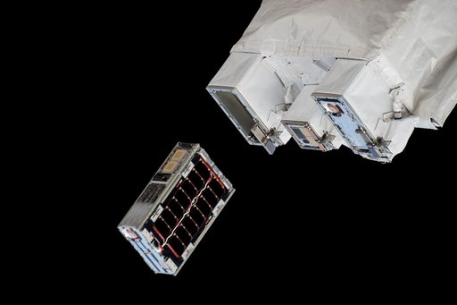 A CubeSat is ejected into Earth orbit from a small satellite orbital deployer