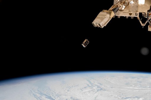 A CubeSat is ejected into Earth orbit from a small satellite orbital deployer