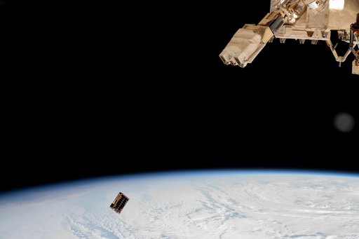 A CubeSat is ejected into Earth orbit from a small satellite orbital deployer