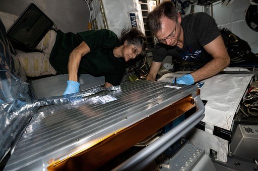 Astronauts Suni Williams and Nick Hague install the European Materials Ageing experiment