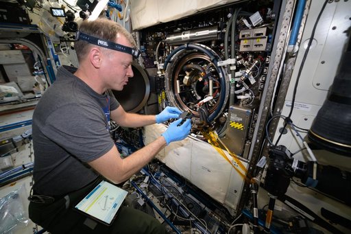 Astronaut Nick Hague processes combustion experiment samples