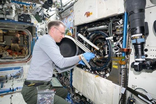 Astronaut Nick Hague swaps samples of materials to observe how they burn in weightlessness