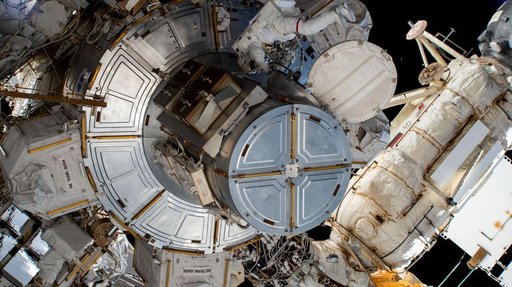 Astronaut Nick Hague exits the Quest airlock to begin a spacewalk