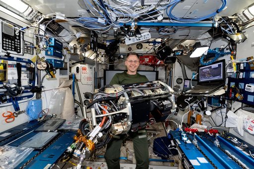 Astronaut Nick Hague handles combustion research hardware