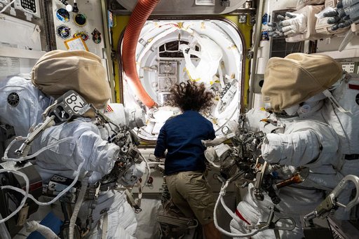 Astronaut Suni Williams works in the Quest airlock readying a pair of spacesuit