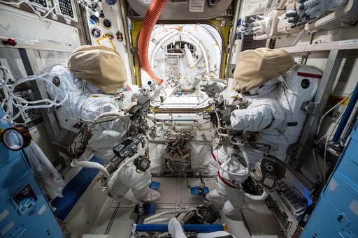 Two spacesuits are staged inside the International Space Station's Quest airlock