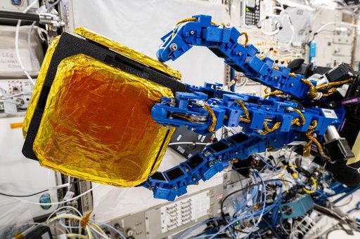 An Astrobee robotic free-flyer with blue tentacle-like arms