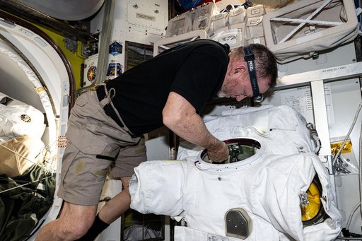 Astronaut Butch Wilmore replaces components on a spacesuit