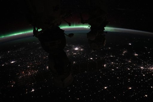 The aurora borealis crowns Earth's horizon above Canada