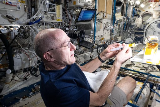 Astronaut Don Pettit injects yellow ink into a ball of water