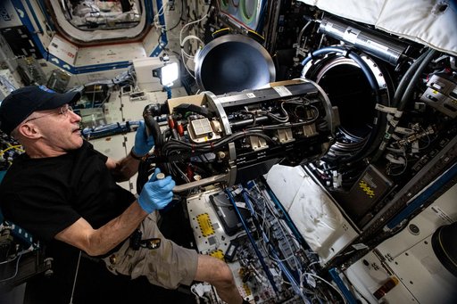 Astronaut Don Pettit inserts research hardware into the Combustion Integrated Rack