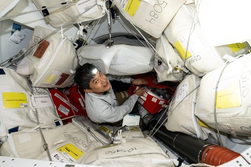 JAXA astronaut Takuya Onishi unpacks cargo stowed inside Dragon