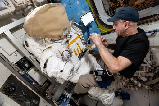 Astronaut Don Pettit inspects a spacesuit