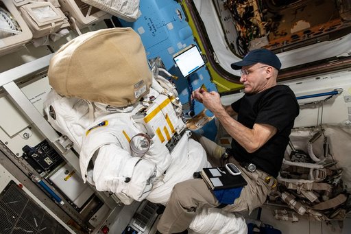 Astronaut Don Pettit inspects a spacesuit