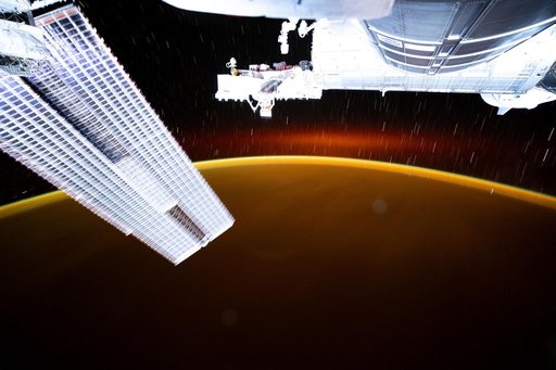 Star trails and an atmospheric glow blanket Earth's horizon