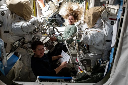Astronauts Anne McClain and Nichole Ayers checkout spacesuit hardware in the Quest airlock