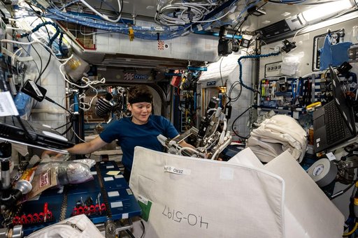 Astronaut Anne McClain gathers cargo to be packed inside the SpaceX Dragon cargo spacecraft