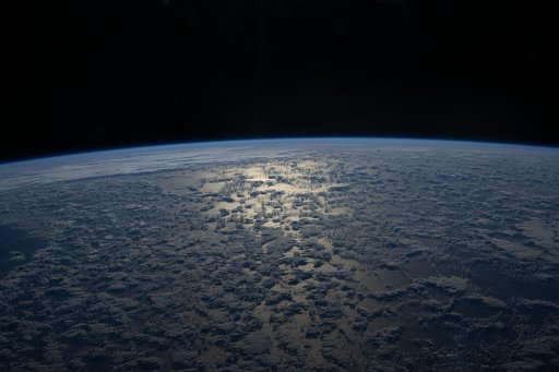 The Sun's glint beams off a partly cloudy Indian Ocean