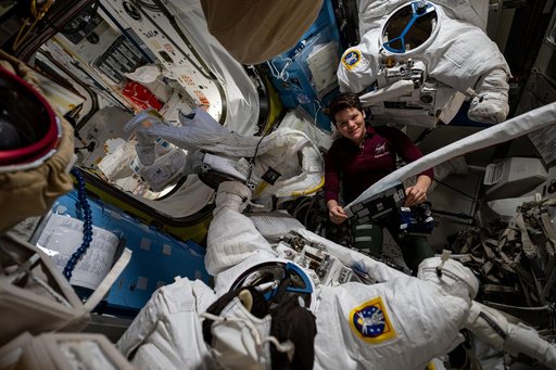 NASA astronaut Anne McClain checks out a pair of spacesuits