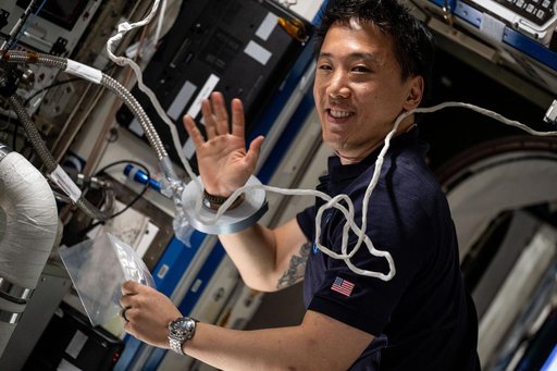 Astronaut Jonny Kim services an experimental carbon dioxide removal device