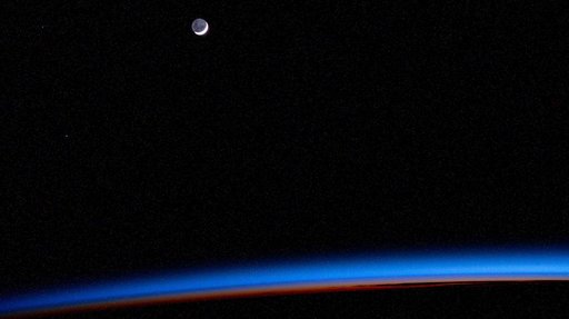 The waning crescent Moon above Earth's horizon
