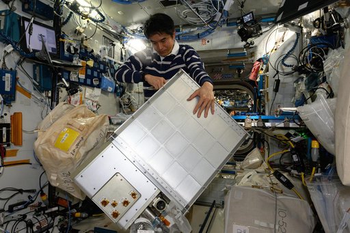 JAXA astronaut Takuya Onishi replaces components on an experimental carbon dioxide removal device