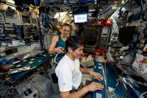 Astronaut Nichole Ayers trims Astronaut Takuya Onishi's hair