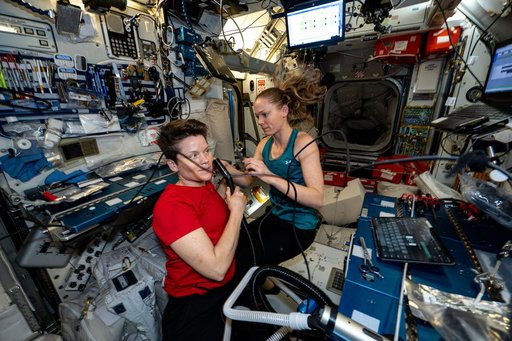 Astronaut Nichole Ayers trims Astronaut Anne McClain's hair