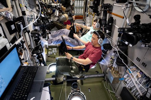 Expedition 73 flight engineers practice an emergency drill on computer tablets